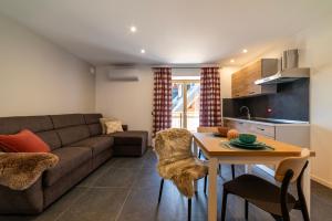 un soggiorno con un divano e un tavolo di Lussari Style Apartments a Tarvisio Altre 69 foto