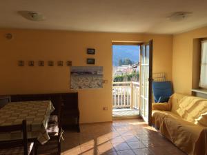 sala de estar con sofá y puerta corredera de cristal en Appartamento Bosco dei Veli, en Panchia