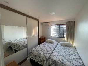 a hotel room with two beds and a mirror at Flat Acolhedor e Familiar in Fortaleza +31 photos