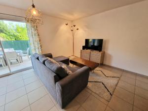 a living room with a couch and a tv at La perle de Dordogne in Le Bugue