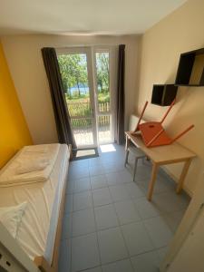 a bedroom with a bed and a desk and a window at Centre Moulin Mer in Logonna-Daoulas