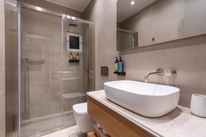 a bathroom with a white sink and a shower at Stylish Suite in Rhodes Town