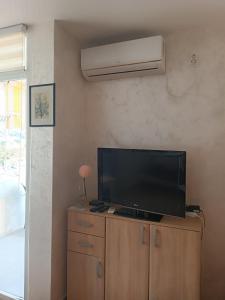 a flat screen tv sitting on top of a dresser at Zevs Apartmani 1 in Igalo