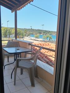 a balcony with a table and chairs and a view of the beach at ΤΑ ΩΡΑΙΑ ΤΗΣ ΑΘΗΝΑς in Skala Mistegnon