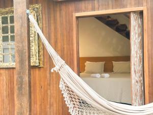 Cabana Com Hidro Na Natureza Em Mariscal 01 في بومبينهاس: أرجوحة معلقة في غرفة مع سرير