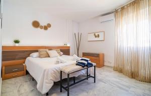 a bedroom with a bed and a chair in it at Awesome Apartment In Benalmadena in Benalmádena +8 photos