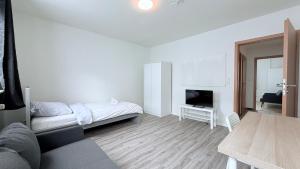 un soggiorno bianco con letto e tavolo di Apartments Neumünster für Firmen & Monteure a Neumünster