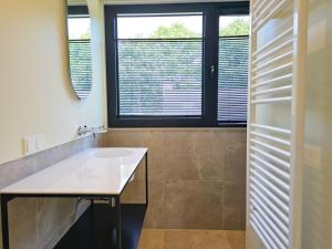 Un baño con lavabo y ventana. en Luxe vakantievilla BG04, en Biggekerke 32 fotos más