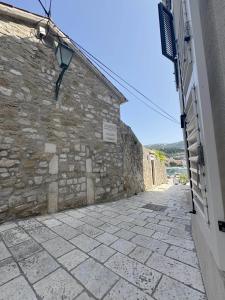 een steegje met een stenen muur en een straat bij Rooms Old Town in Rab