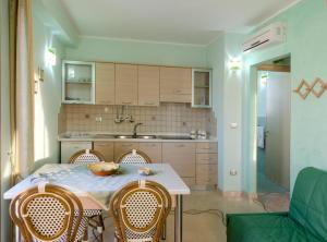 丽都玛里尼Residence Salù Lido Marini的一间带桌子和椅子的厨房以及一间厨房