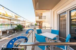 a balcony with blue chairs and a table at Vicky Rooms in Paralia Dionysiou