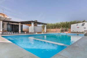 a large swimming pool with blue water at Finca El Abuelo in Lepe