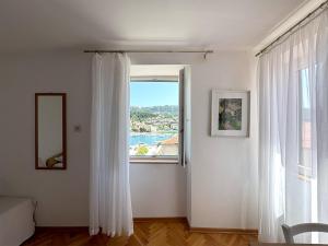 a room with a window with a view of the water at Rooms Old Town in Rab