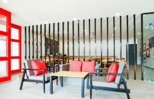 a room with two chairs and a table with red pillows at Super Townhouse Prithvi Resort Near Phoenix Palassio in Lucknow
