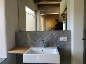 a man taking a picture of a sink in a bathroom at Knappnhof in Campo di Trens