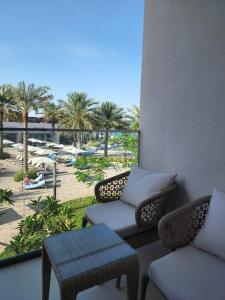 Ocean View Address Fujairah Beach Resort的设有带桌椅的阳台,享有海滩美景
