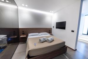 a bedroom with a bed with two towels and a television at VS LUXURY SUITE with SPA in Bari