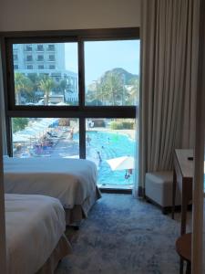 Ocean View Address Fujairah Beach Resort的酒店客房带两张床,能欣赏泳池景色。 更多22张照片