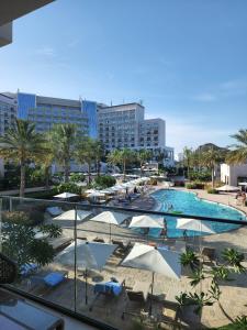 Ocean View Address Fujairah Beach Resort的一个带遮阳伞的游泳池和一个度假村