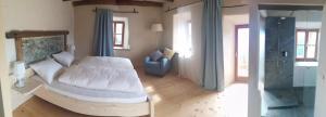 a bedroom with a white bed and a blue chair at Knappnhof in Campo di Trens