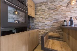 a kitchen with wooden cabinets and a brick wall at Les Chalets Autrichiens - Megève in Megève +14 photos