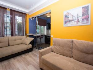 sala de estar con sofá y pared amarilla en ApartLux Sokolnicheskaya Suite, en Moscú
