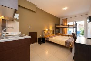 a bathroom with a bedroom with a bed and a sink at Vicky Rooms in Paralia Dionysiou