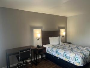 a hotel room with a bed and a desk with a desk at Motel 6 Saint George, SC – I-95 in Saint George