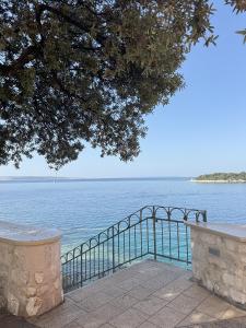een uitzicht op een waterlichaam met een metalen reling bij Rooms Old Town in Rab