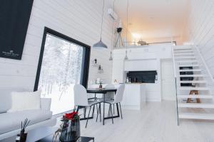 a kitchen and living room with a table and chairs at Polaris Villas - Villa BLÄKK in Muonio