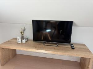a flat screen tv sitting on top of a wooden table at VC House Estúdios, Coimbra in Coimbra