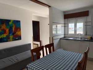 a kitchen with a table and a couch and a table and a table at Casa da Praia in Praia da Vieira