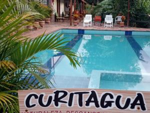 库里蒂Curitagua Hotel Campestre的游泳池前的标志