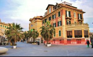 an old building with palm trees in front of it at Brezza Marina in Lido di Ostia