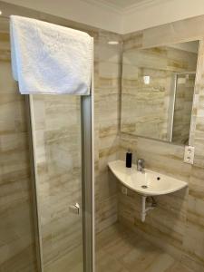 a bathroom with a sink and a shower at Andora Vendégház - Bóly in Bóly
