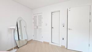 a dressing room with white cabinets and a mirror at Yeon Stay Miryang in Miryang +26 photos