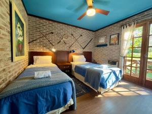 a bedroom with two beds and a ceiling fan at Lindo sítio com piscina, quadra de tênis e lago in Nova Petrópolis +81 photos
