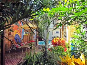 a patio with chairs and flowers in a garden at Pousada Cana Caiana in Paraty
