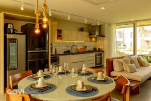 eine Küche und ein Wohnzimmer mit Tisch und Stühlen in der Unterkunft Casa Anamá em condomínio Naluum H9 by Qavi in Passo de Camarajibe