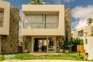 ein Haus mit großen Fenstern und Palmen in der Unterkunft Casa Anamá em condomínio Naluum H9 by Qavi in Passo de Camarajibe