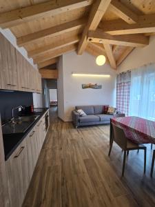 a kitchen and living room with wooden ceilings at Miravalli Home in Gosaldo +36 photos
