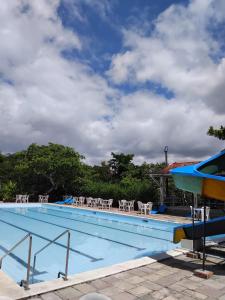 una piscina con sedie e cielo nuvoloso di Viver Hotel Fazenda a Moreno Altre 8 foto