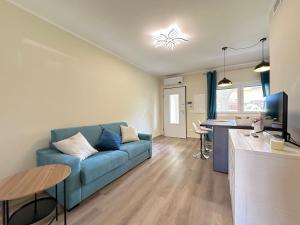 a living room with a blue couch and a table at Tramontana Suite Apartment in Marina di Grosseto