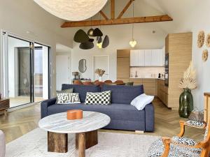 a living room with a blue couch and a table at 765 - Maison moderne avec piscine privative. in Erquy