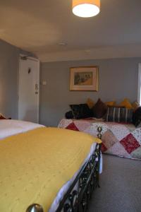 
a hotel room with a bed, chair, lamp and window at Horse & Groom B&B in Westbury

