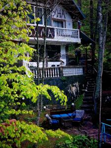 a house with a porch and a blue bench in front of it at Villa Byala Luna - Guest House in Bistriza