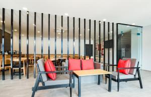 a room with two chairs and a table with red pillows at Super Townhouse Prithvi Resort Near Phoenix Palassio in Lucknow