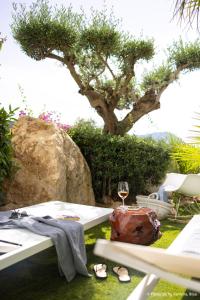 a picnic table with a glass of wine and a tree at Hacienda Na Xamena, Ibiza in Na Xamena