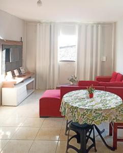 a living room with a table and a red couch at Itapuã Pousada e Hostel Corais in Salvador
