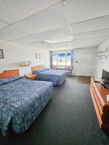 una camera d'albergo con due letti e una televisione di Katahdin Valley Motel 